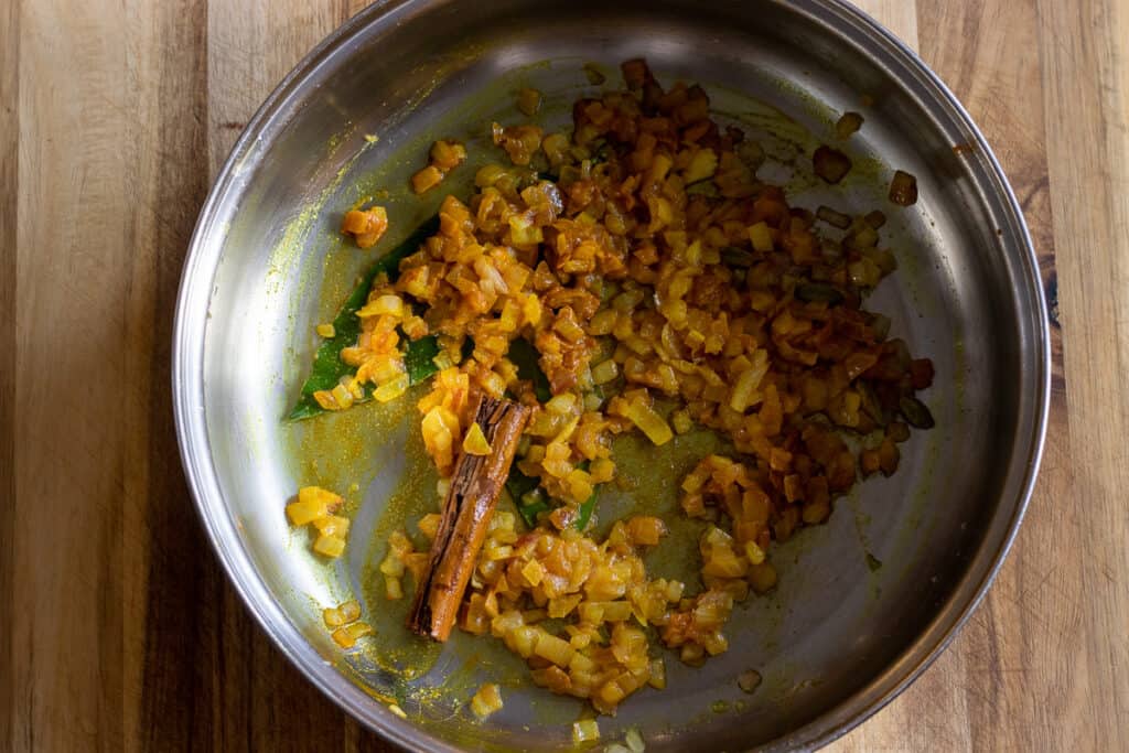 Sautéing the spices until fragrant.