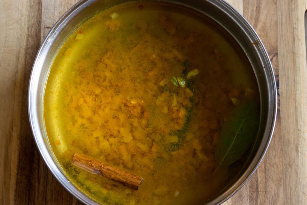 Vegetable stock is added to the pan.
