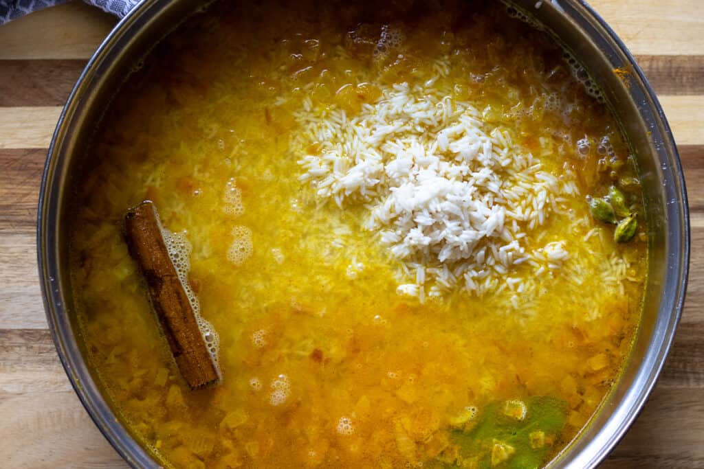 Soaked and washed rice is added to the pan.