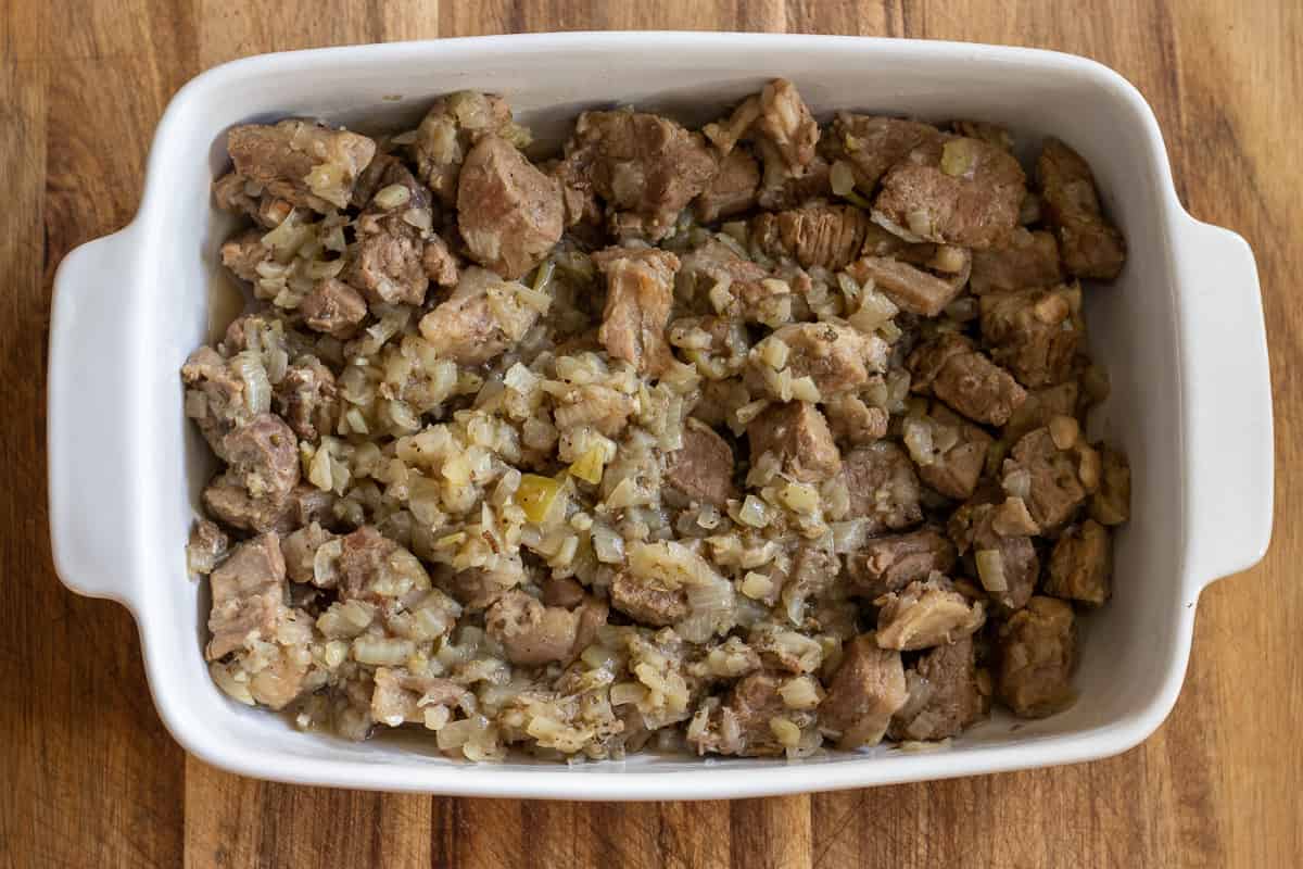 tender lamb meat is transferred to a baking dish