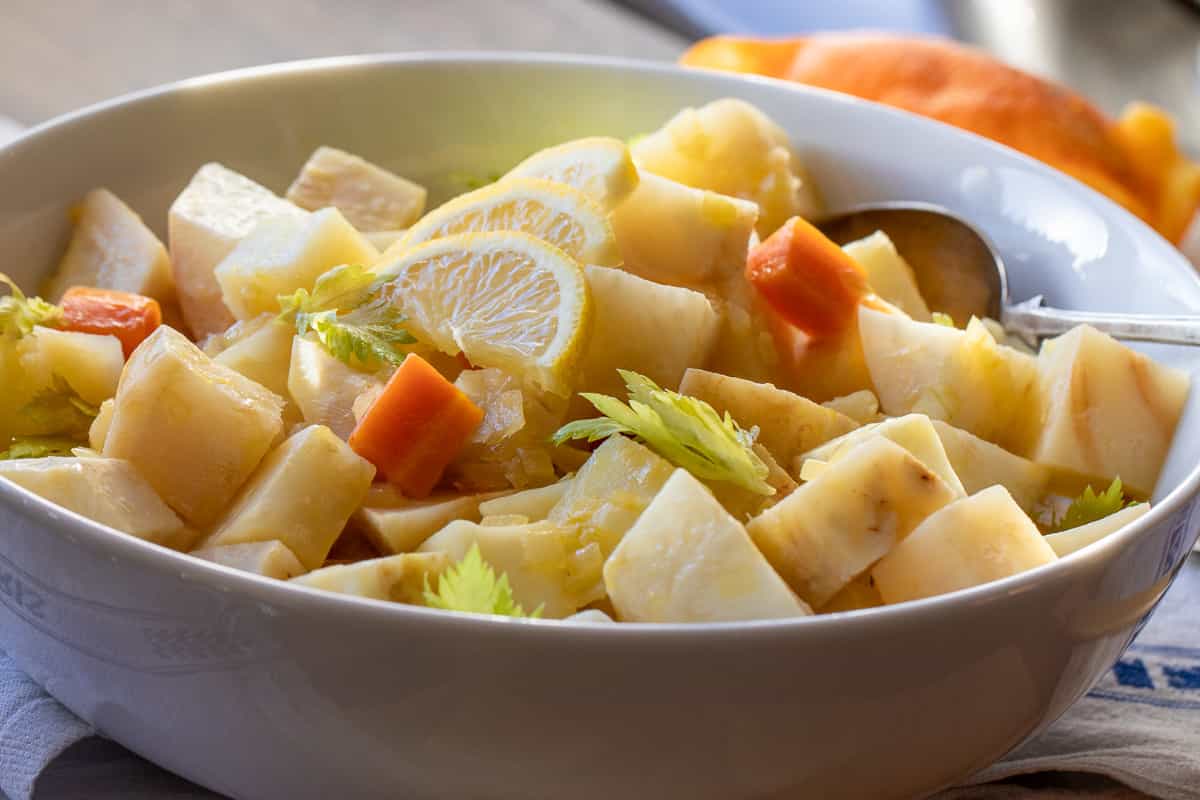 Zeytinyagli kereviz yes served with sliced lemon and celery leaves