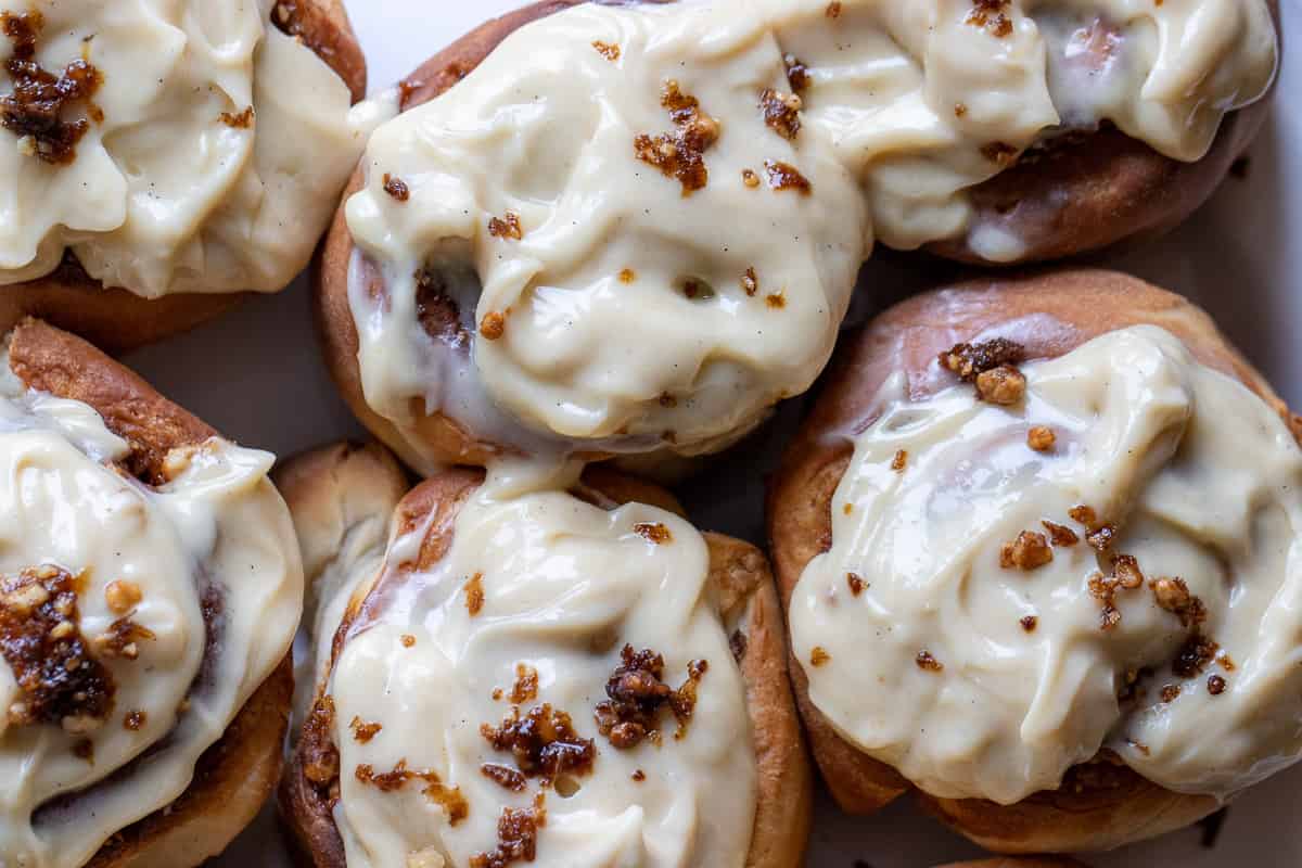 air fryer cinnamon rolls are covered with cream cheese frosting
