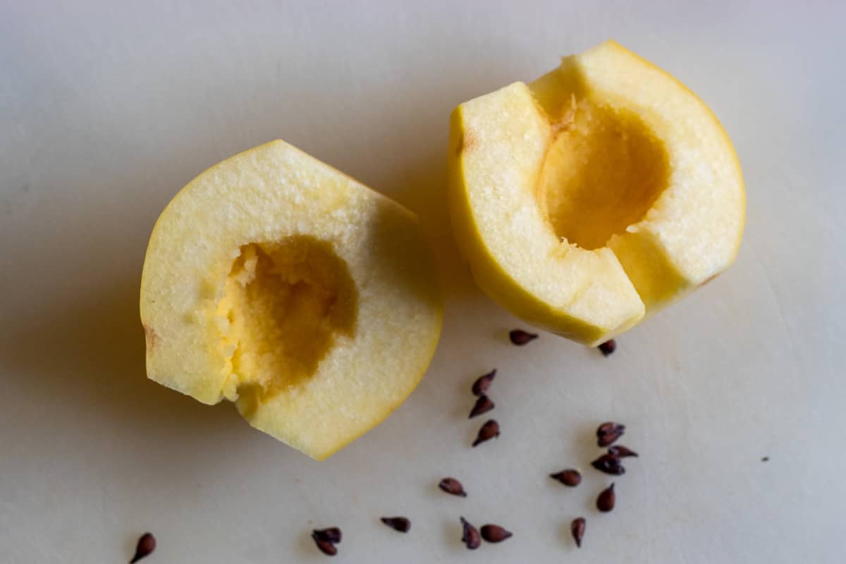 quince fruit is cut in half, cored and deseeded