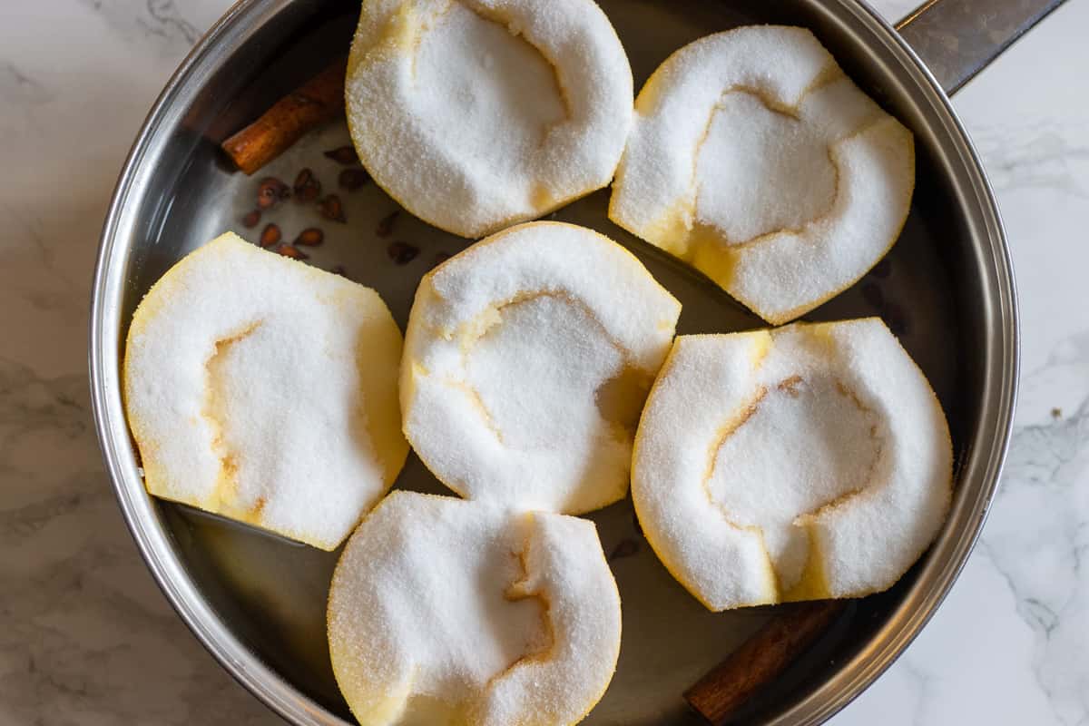 6 quince halves are placed in a pan along with sugar, water and cinnamon stick