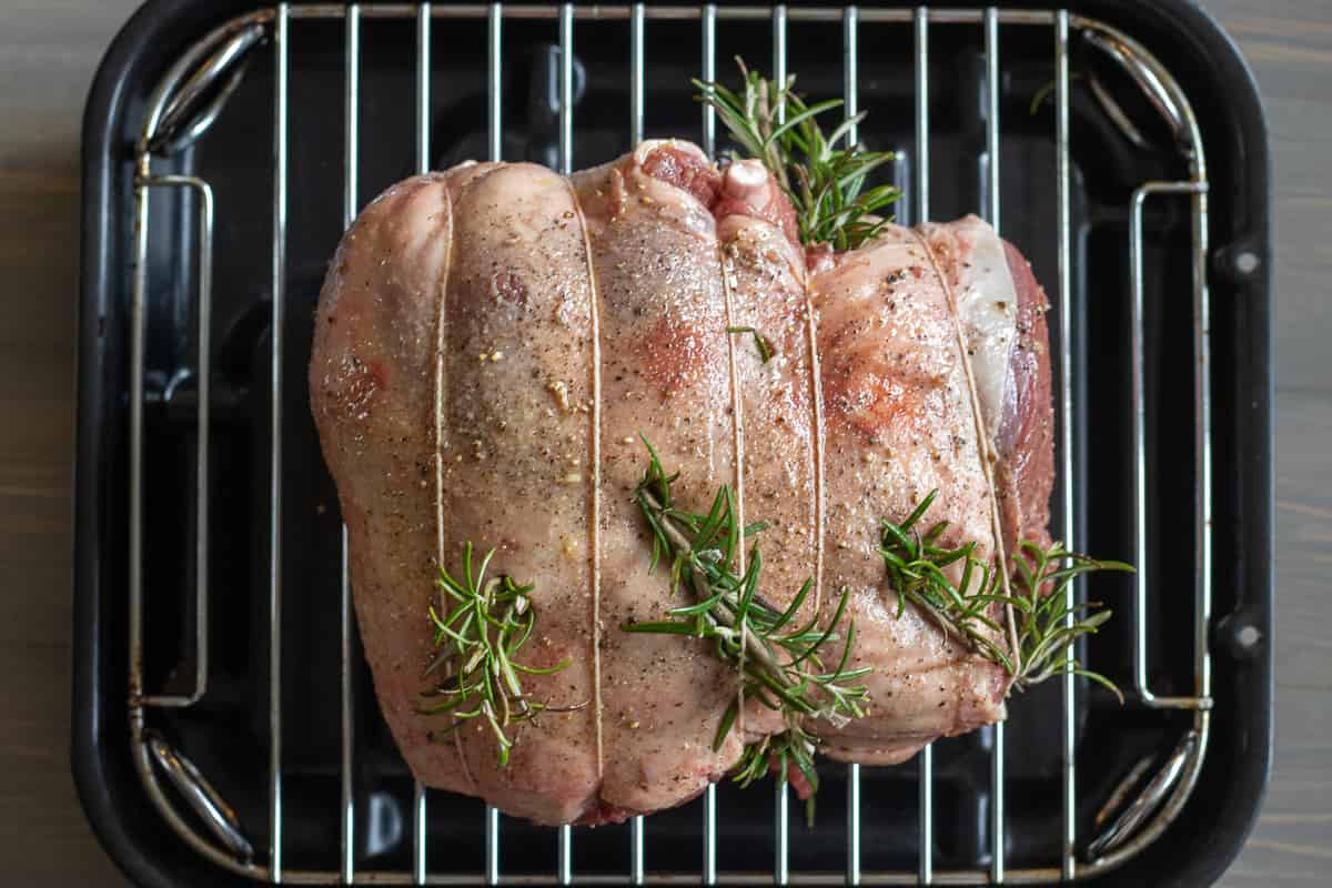 boneless leg of lamb is seasoned with salt and pepper