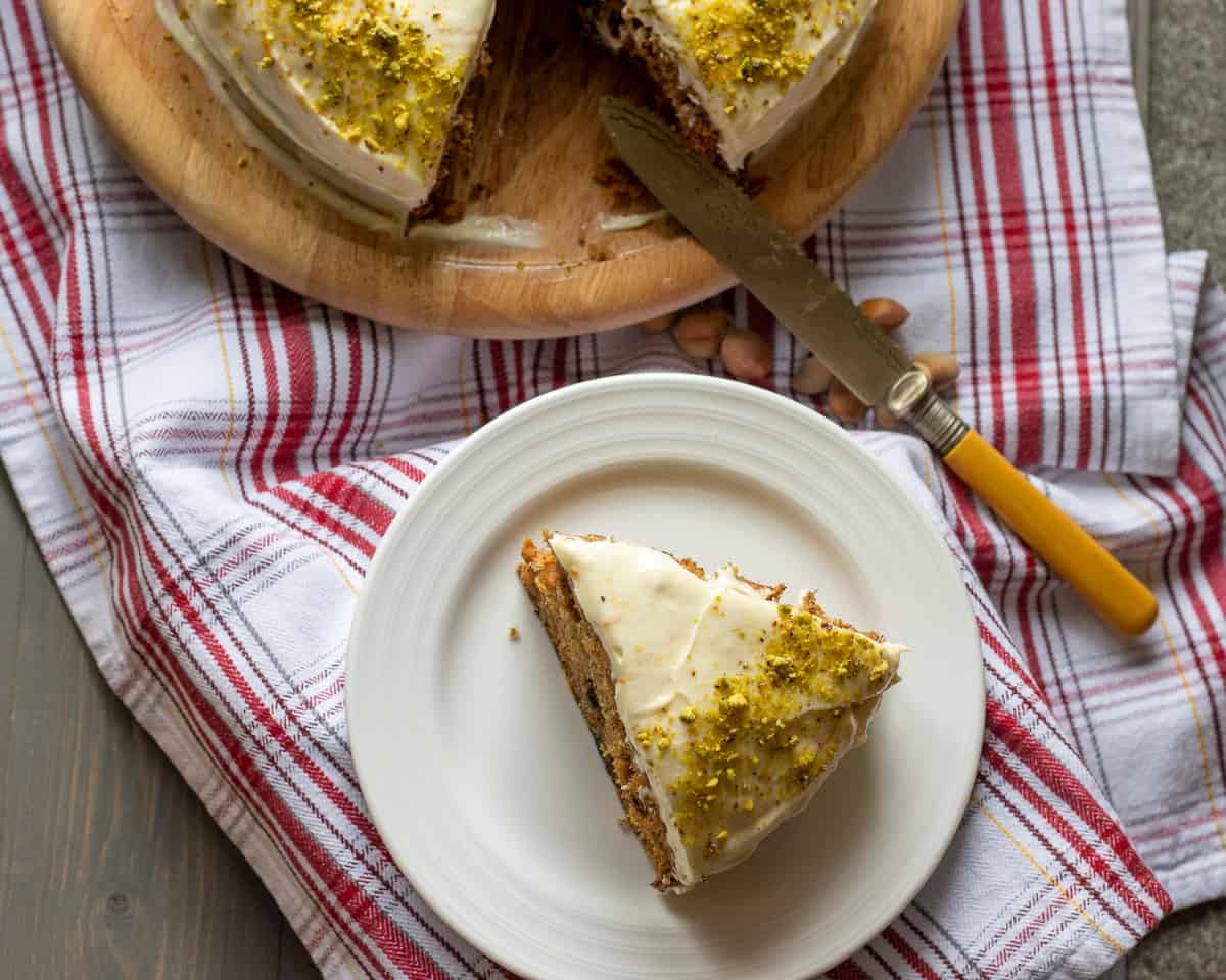 a slice of carrot cake is cut and placed on a plate