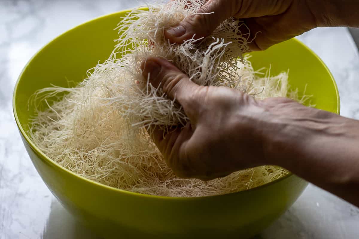 separating the strands of kadaif pastry with fingers