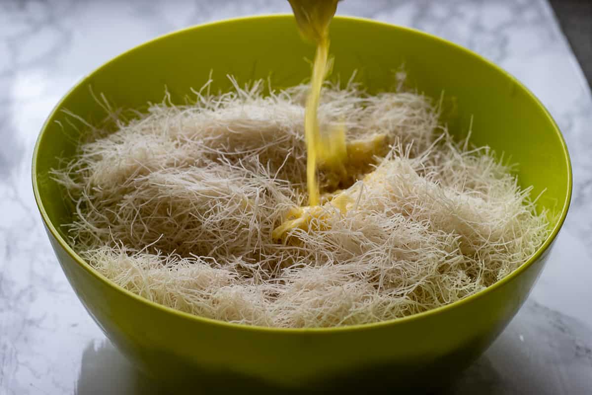 poring melted butter on kadaif pastry