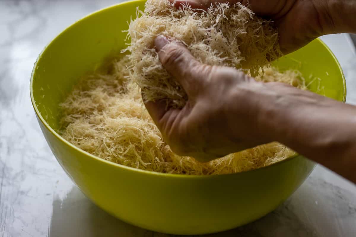 mixing the kadaif pastry with melted butter