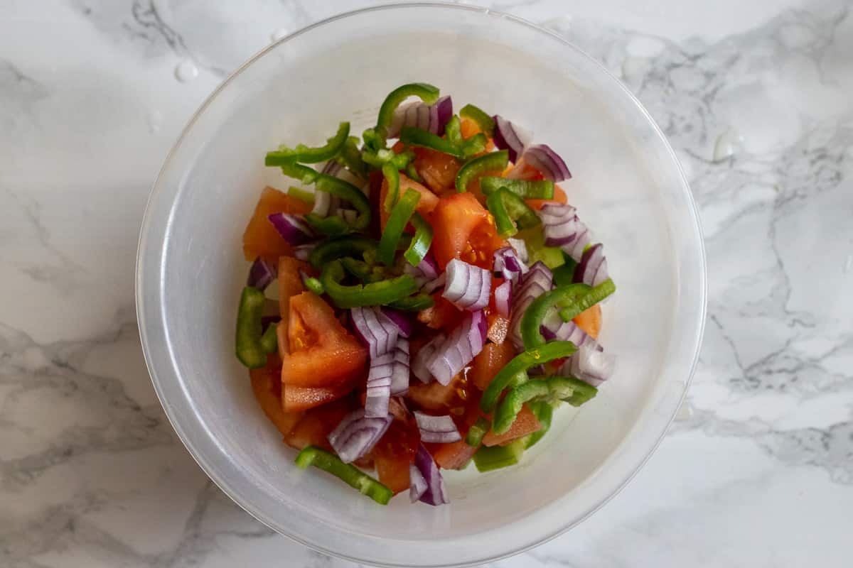 diced onions and peppers are added to the bowl