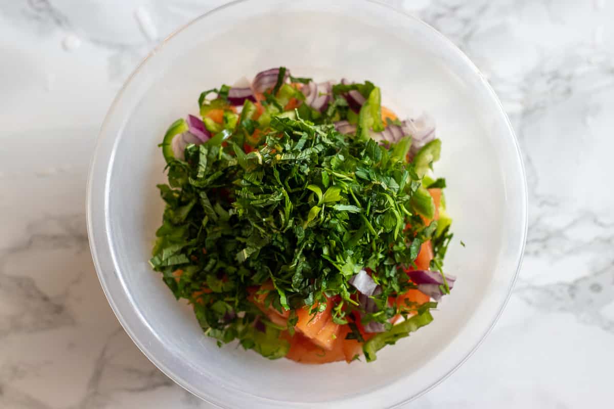 chopped herbs are scattered on Shirazi Salad