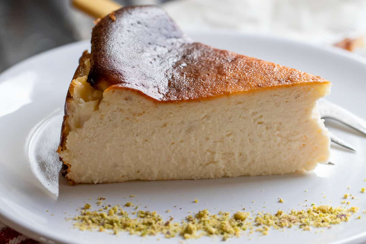 a slice of san Sebastian cheesecake served with pistachio