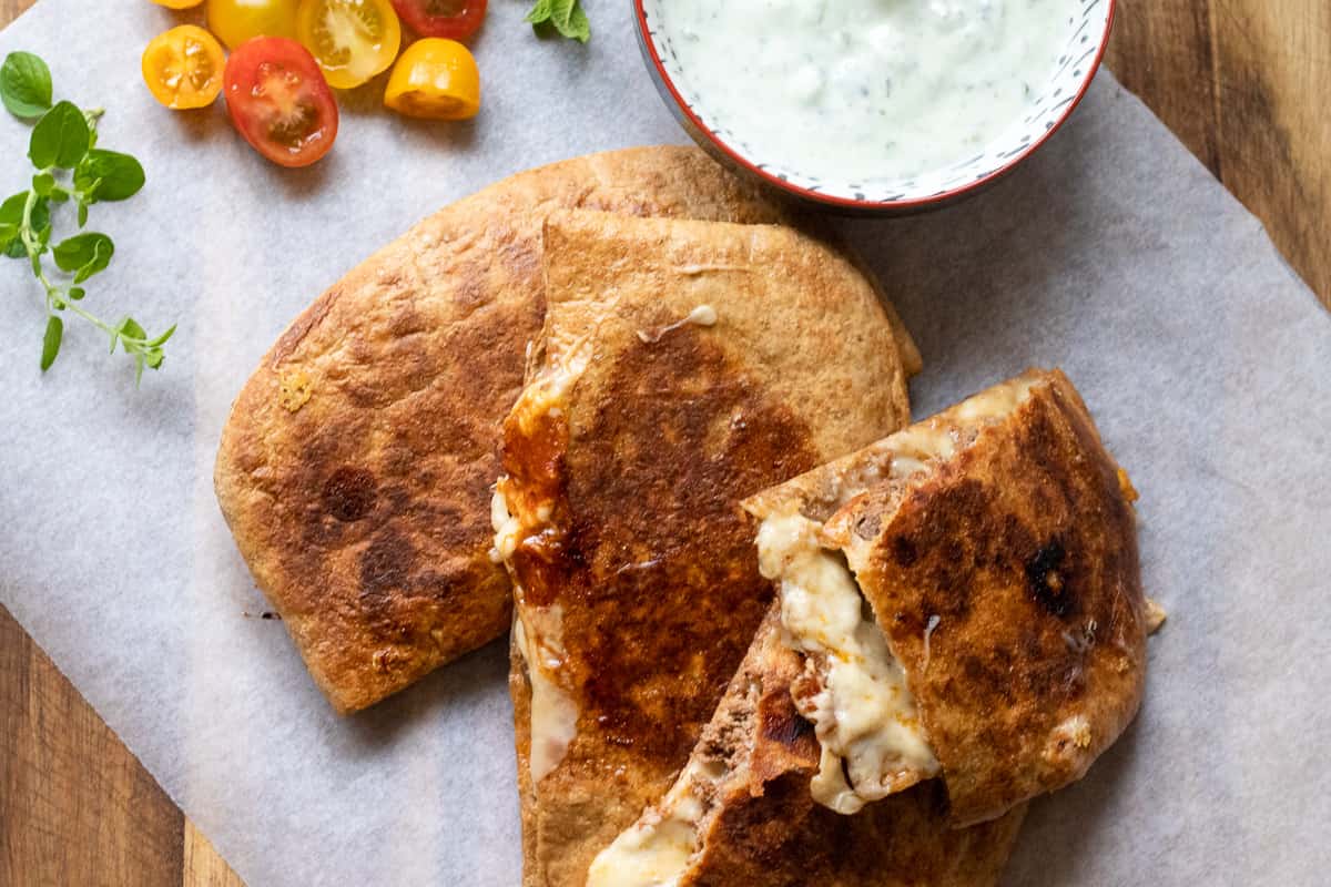Arayes - Stuffed pita served with yogurt sauce and tomatoes
