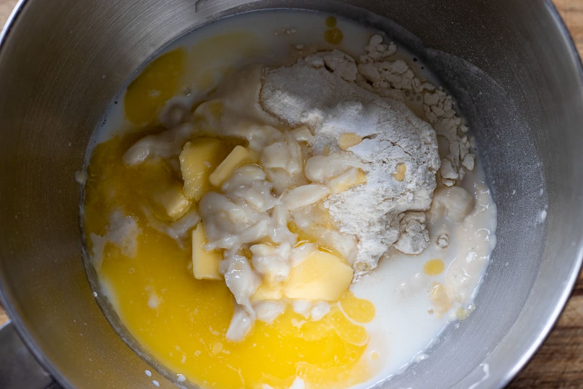 Flour, sourdough starter, salt, honey and melted butter are mixed in a bowl of a stand mixer.