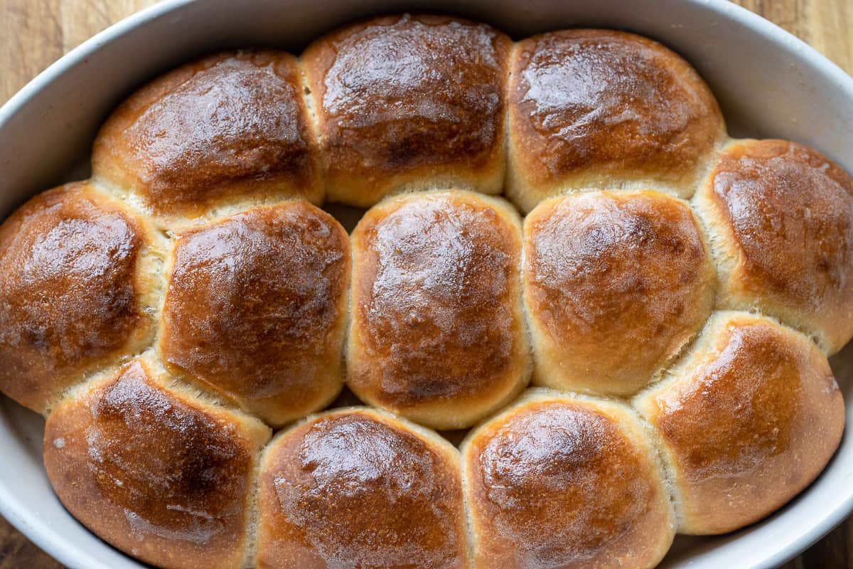 Freshly baked 12 pieces of dinner rolls in a baking pan.