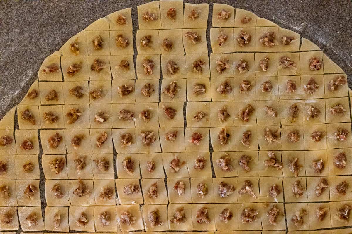 a small amount of meat filling is placed on each square