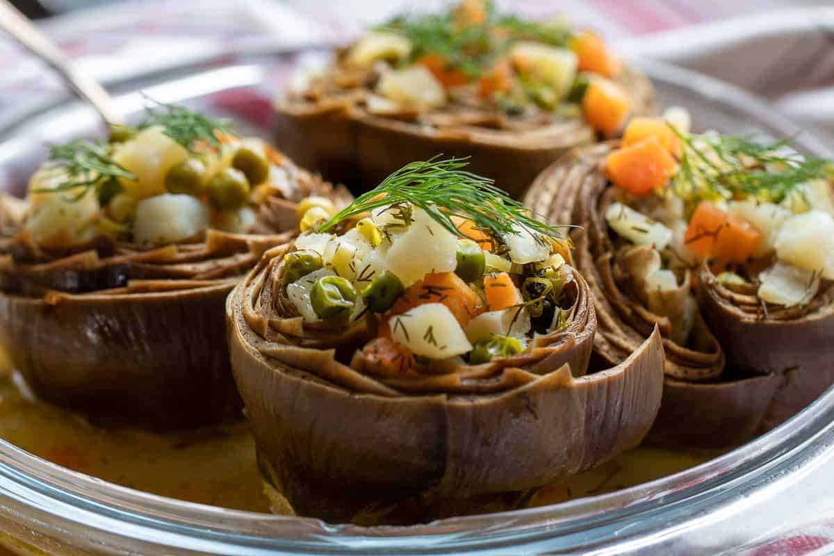 4 stuffed artichokes served in a dish