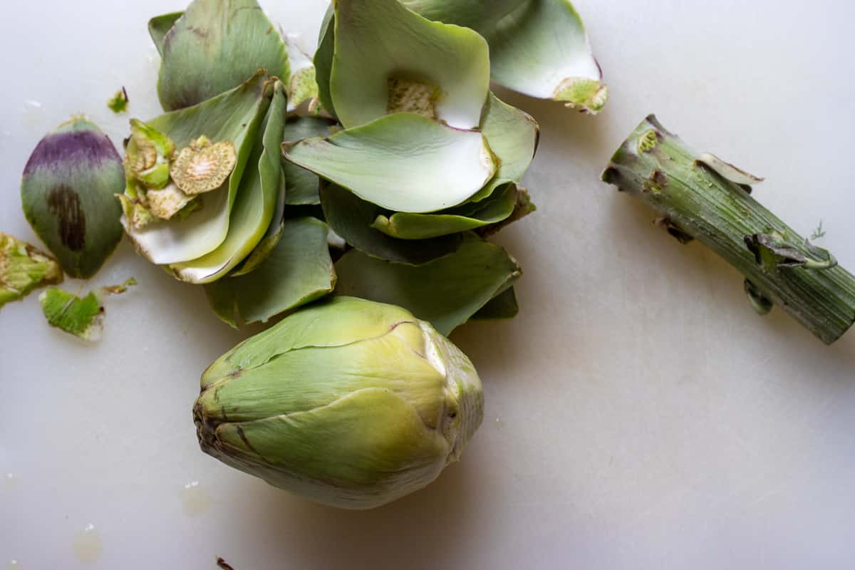 preparing an artichoke for making Zeytinyagli enginar