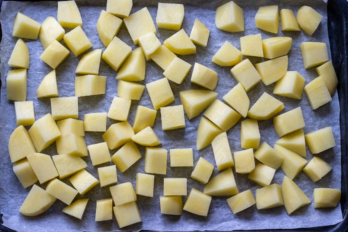 potato cubes are placed on a baking sheet