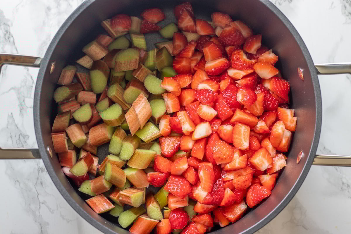 Chopped fruits are placed in a pot.