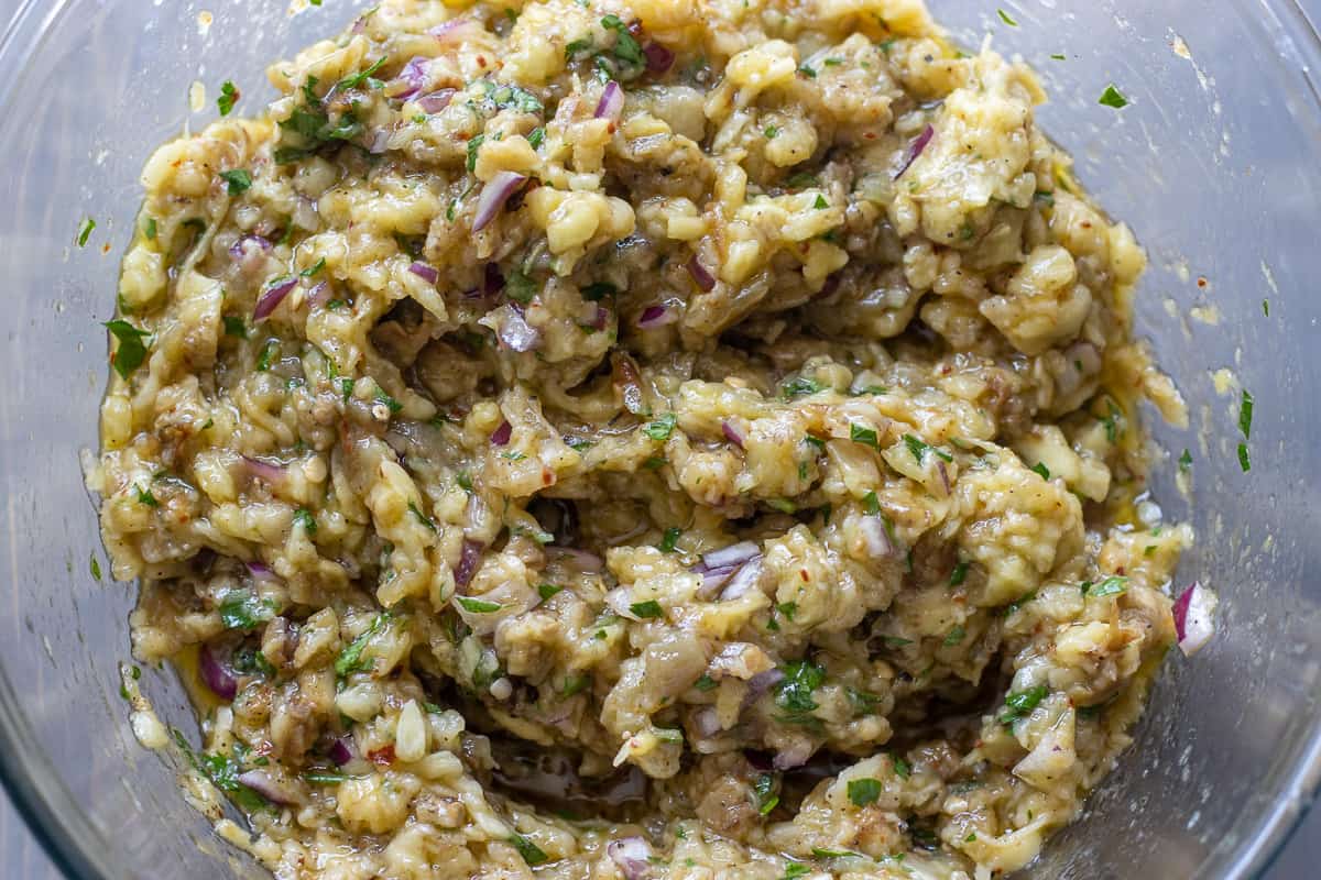 Roasted eggplants, red onions, parsley, olive oil, lemon juice and seasoning are mixed in a bowl