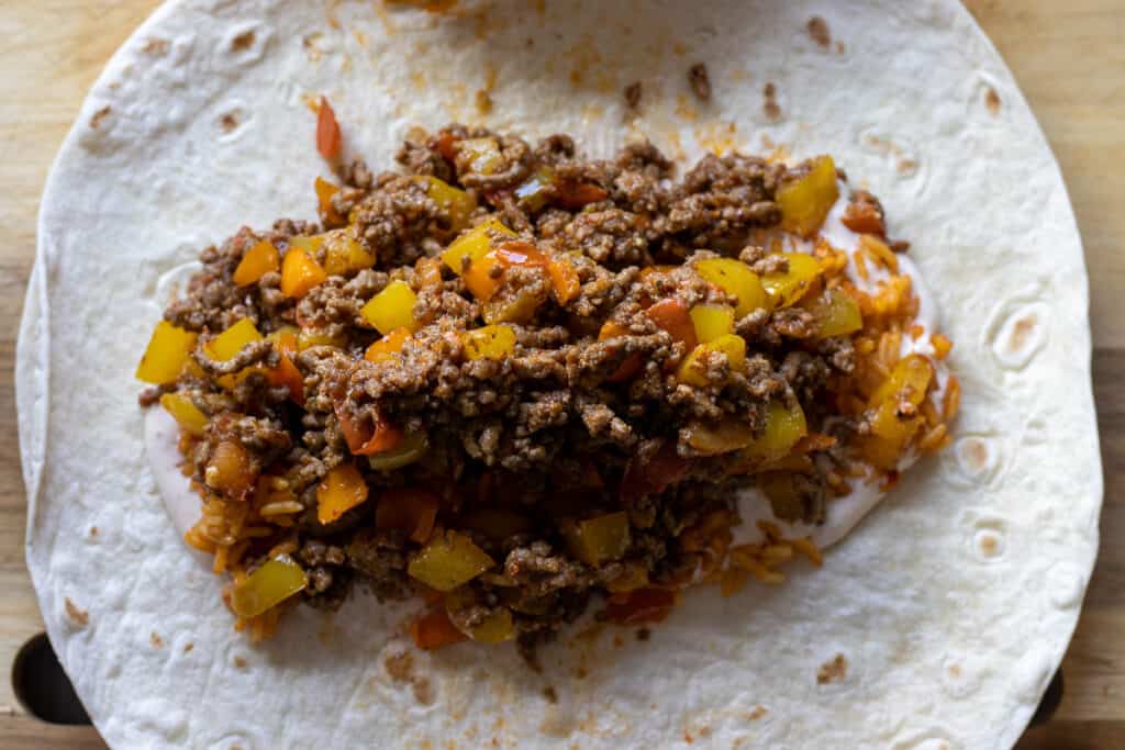 Ground beef filling is added on top of the cooked rice.