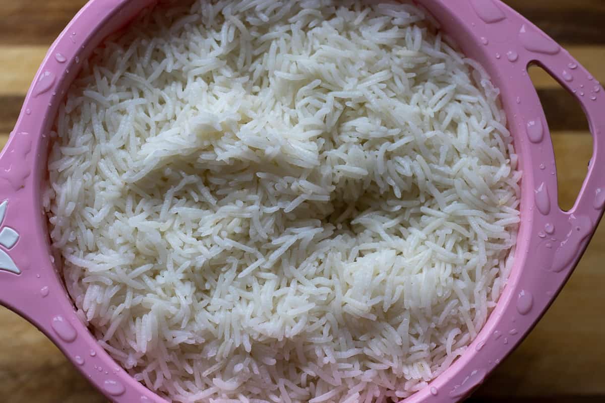 Parboiled rice in a colander for making zereshk polo morph - Persian barberry rice with chicken dish