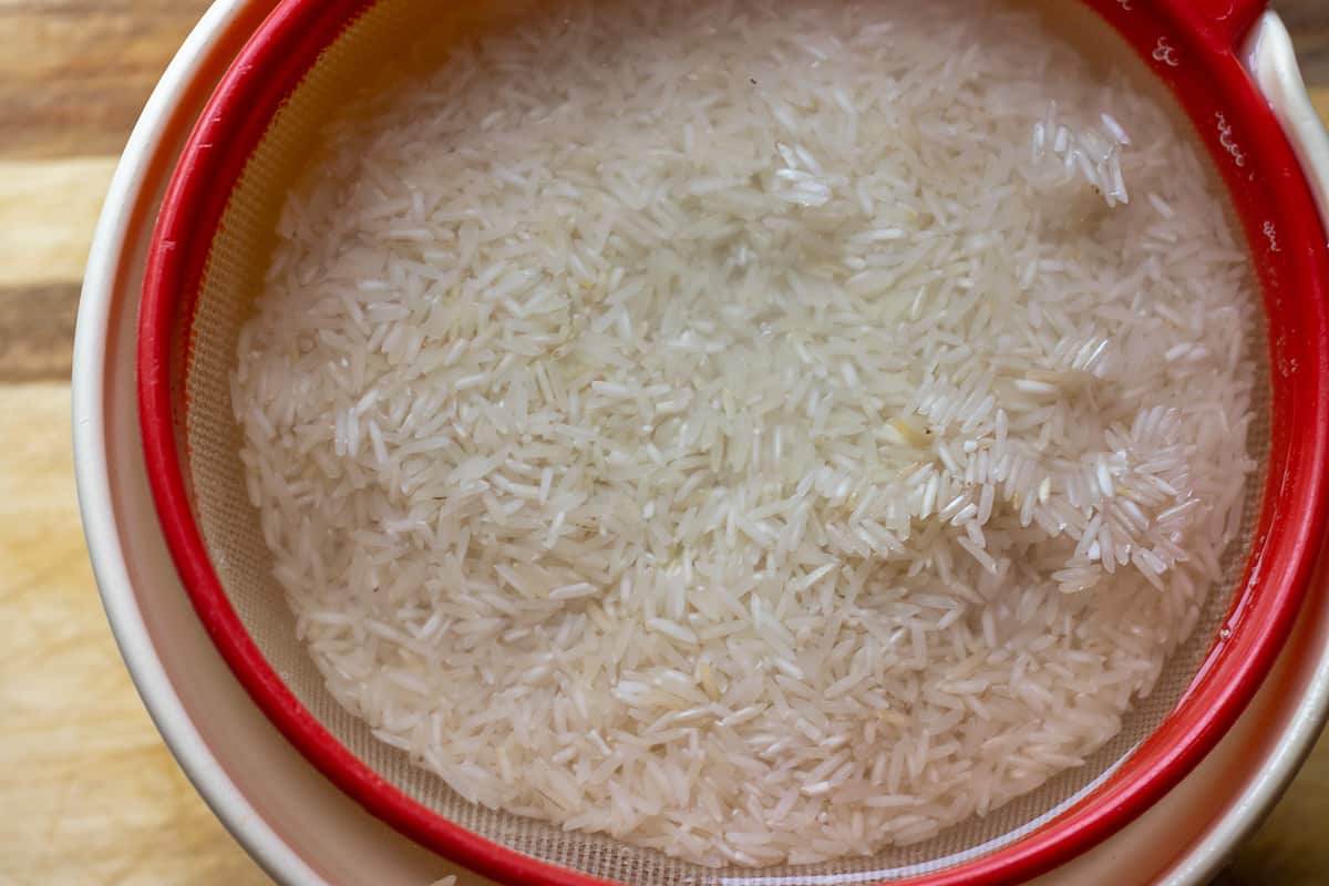 washing the rice for zereshk polo morgue - Persian barberry rice with chicken in a colander
