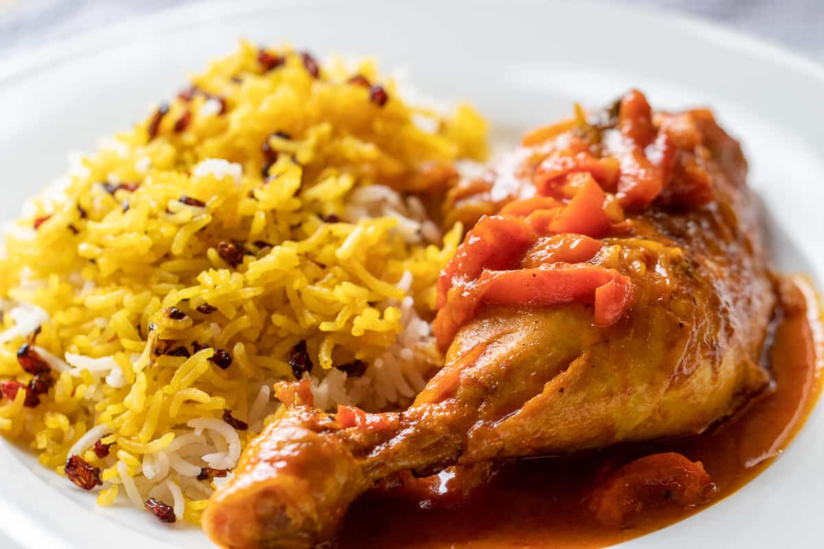 a portion of zereshk polo morph - Persian barberry rice with chicken served on a plate