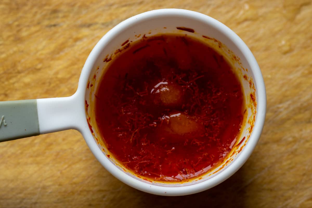 Blooming crushed saffron treads on ice cubes