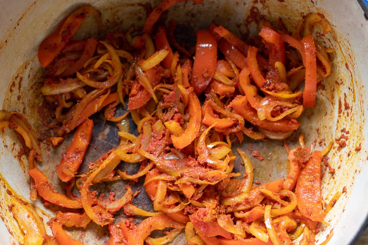 tomato paste and spices are added to sautéed vegetables