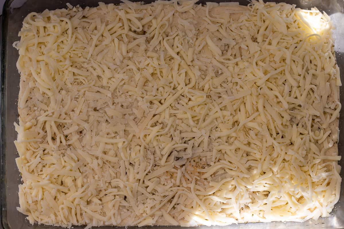 cheese is sprinkled on the dough before baking