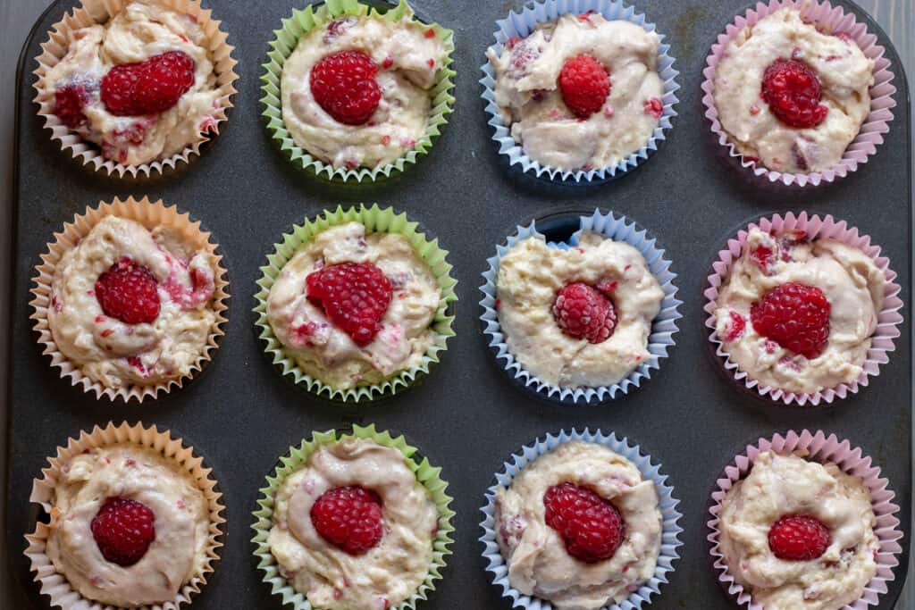 Muffin batter is divided into 12 muffin tins.