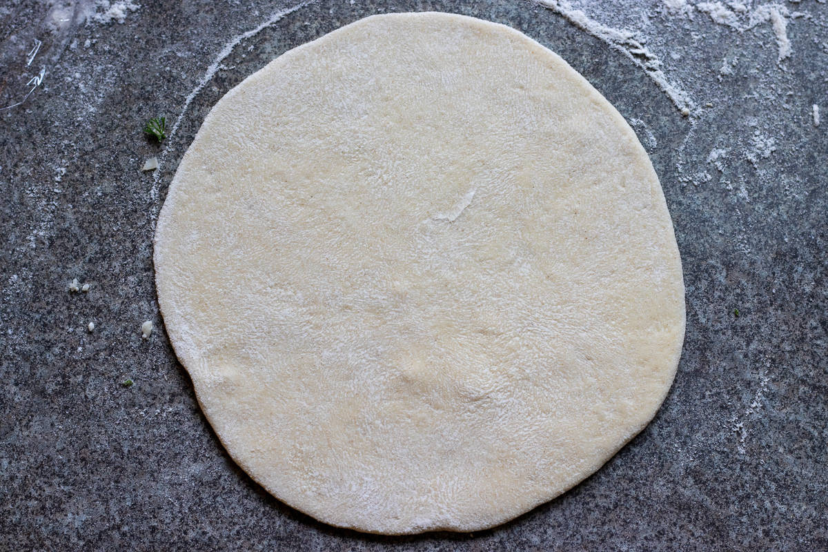 a dough ball shaped into a thin circle