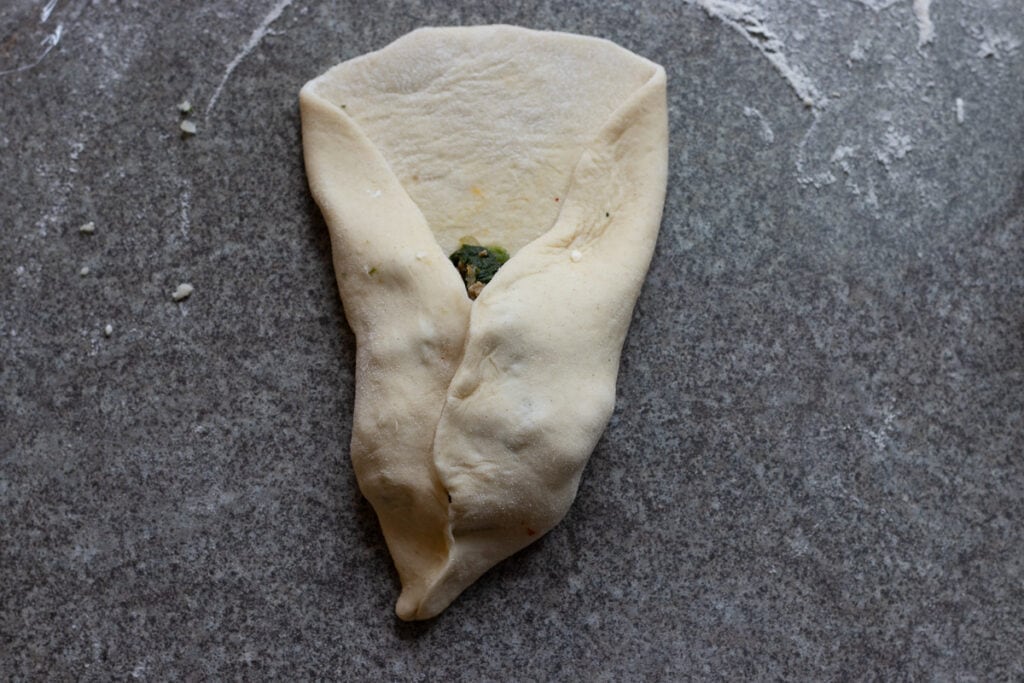 Two sides of the dough brought together at the top, a bit to the side to create a point like a triangle.