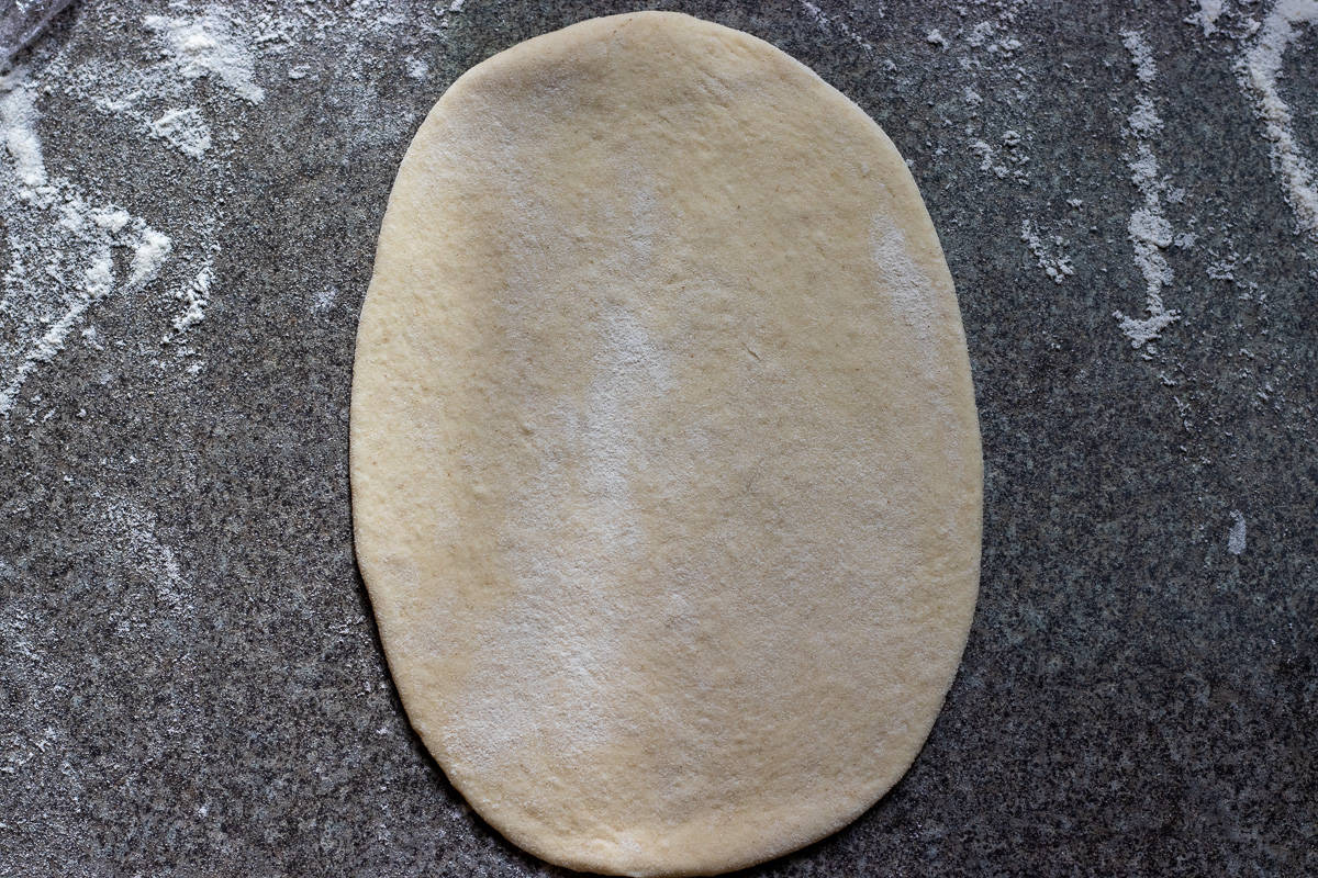 a dough ball rolled out into an oval