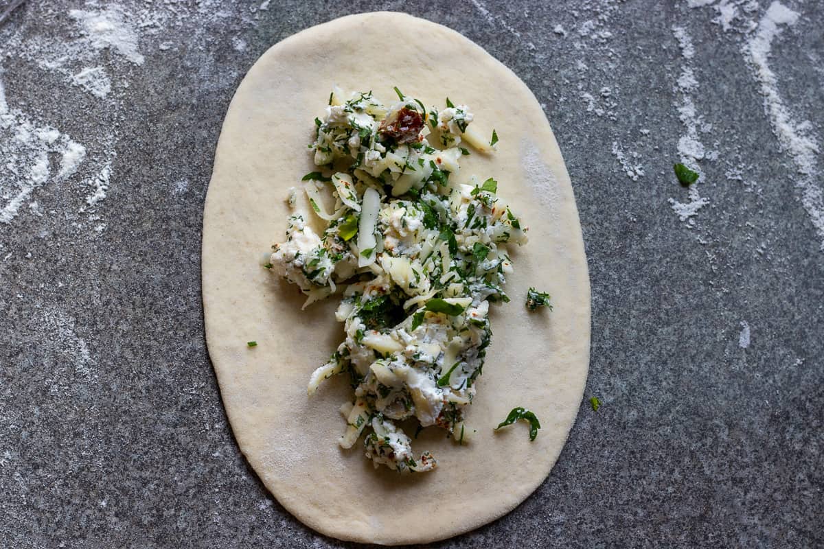 1.5 tablespoon of cheese filling is placed into the middle of the dough
