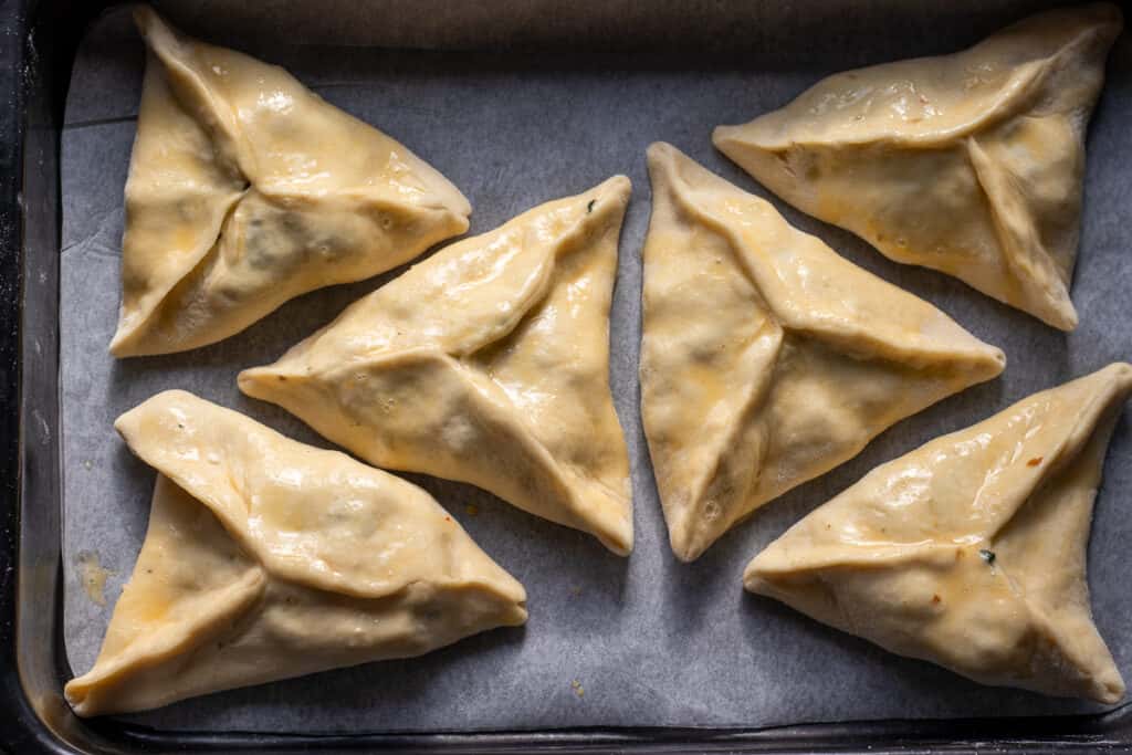 6 pieces of boat shaped fatayer are egg washed