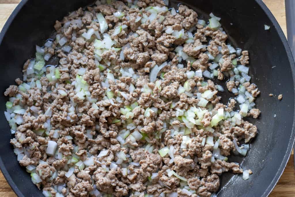 Sautéing chopped onions with ground beef.