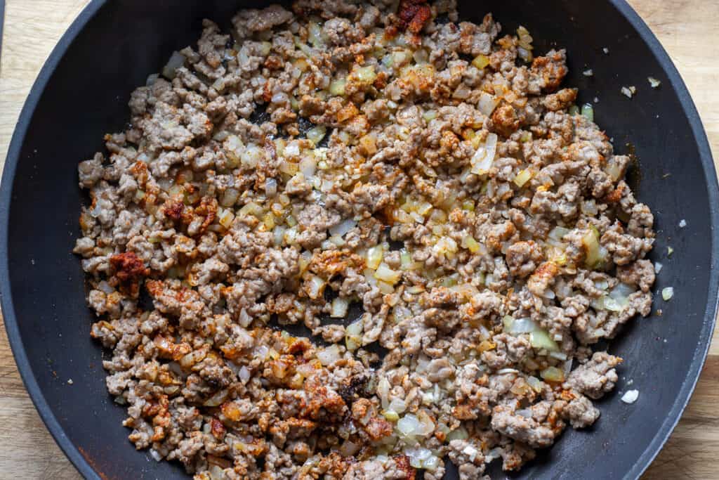 Salt, pepper, and paprika are added to sautéed onions.