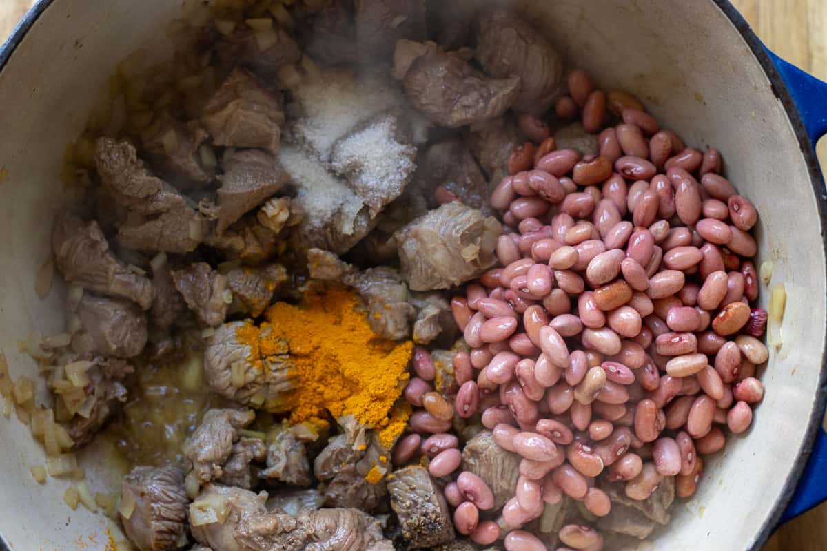 red kidney beans, salt, pepper, and turmeric are added to sautéed onions and lamb