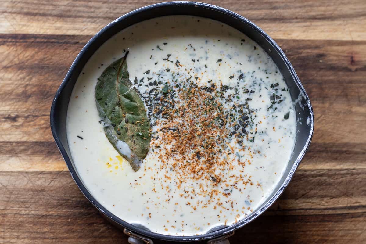 garlic, bay leaf, finely chopped thyme, garlic and seasoning are placed in a saucepan along with milk and cream