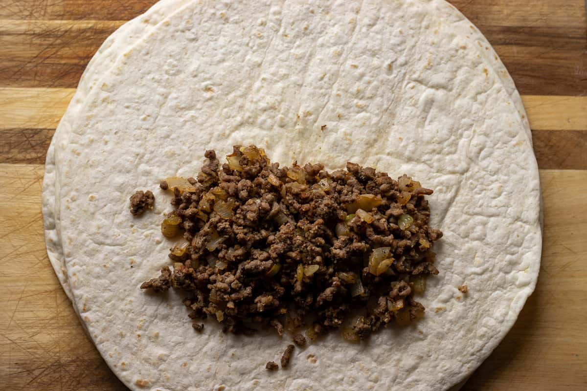 beef filling is placed on a piece of tortilla