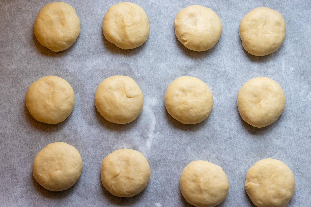 12 dough balls are placed on a tray for a second proofing