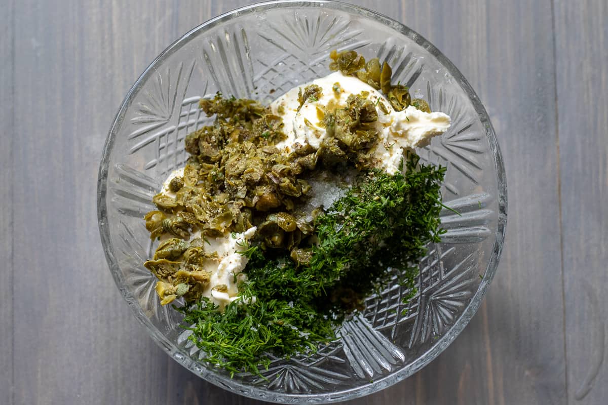 cream cheese, chopped dill, and capers are placed in a bowl