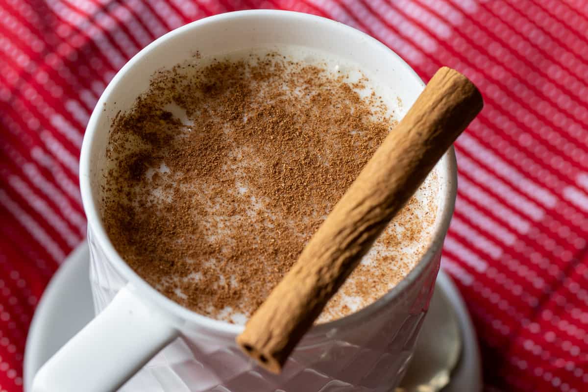 Salep drink served in a white cup garnished with a cinnamon