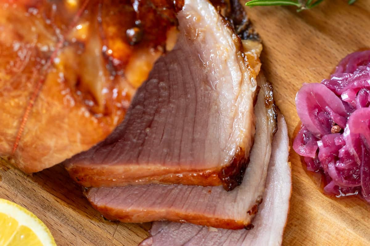 sliced honey baked ham served on a wooden board