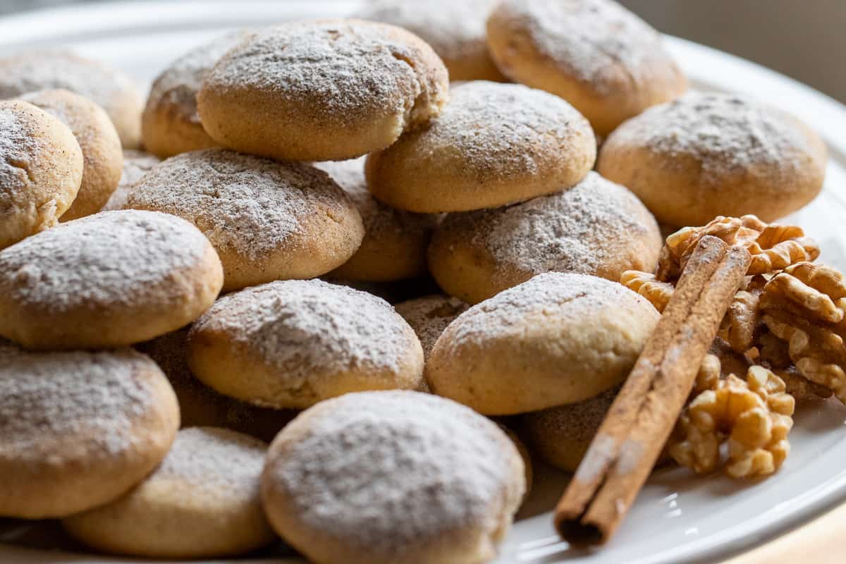 walnut cookies served on a plate with a cinnamon stick and walnut halves