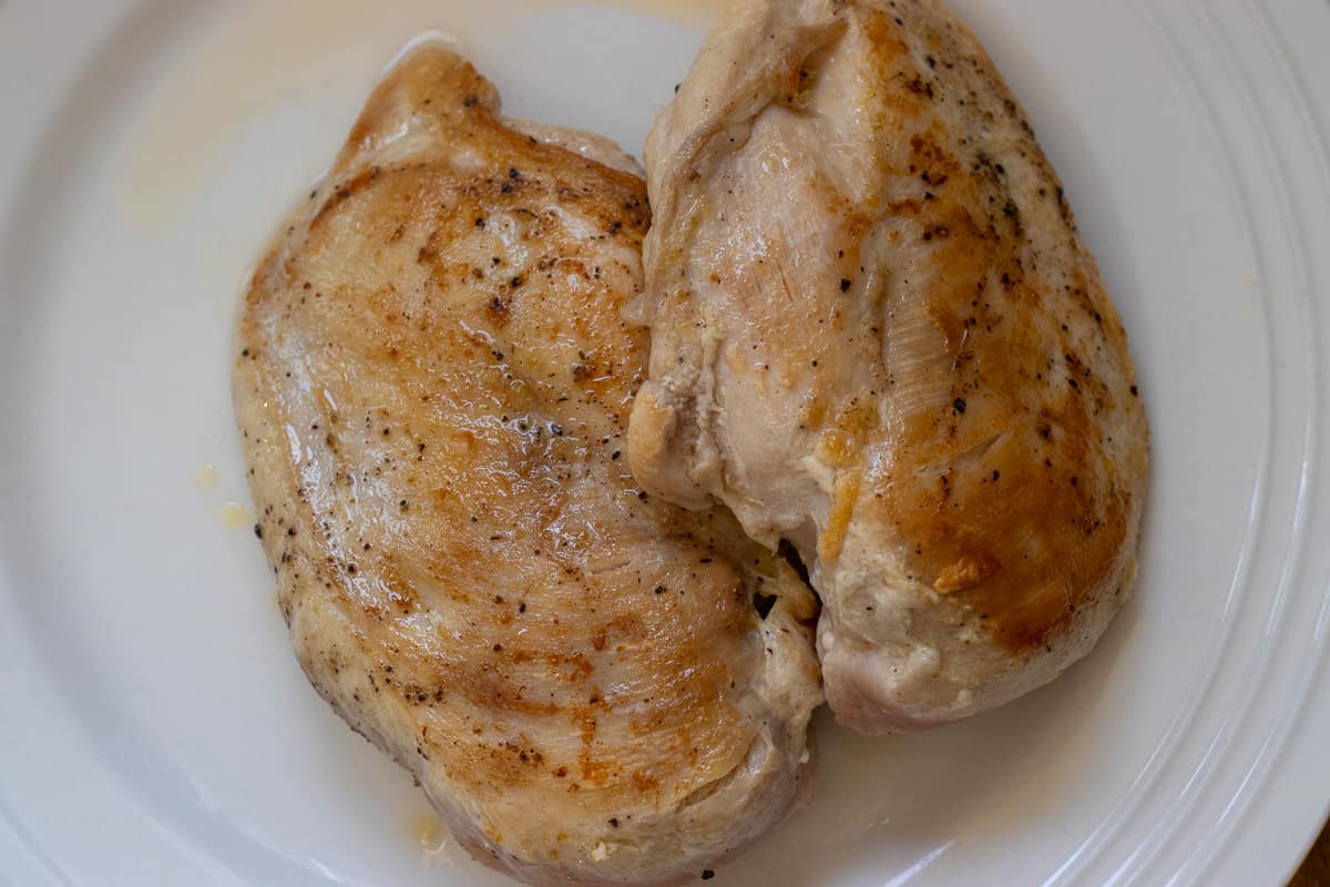 2 pieces of chicken breasts are seared and placed on a plate