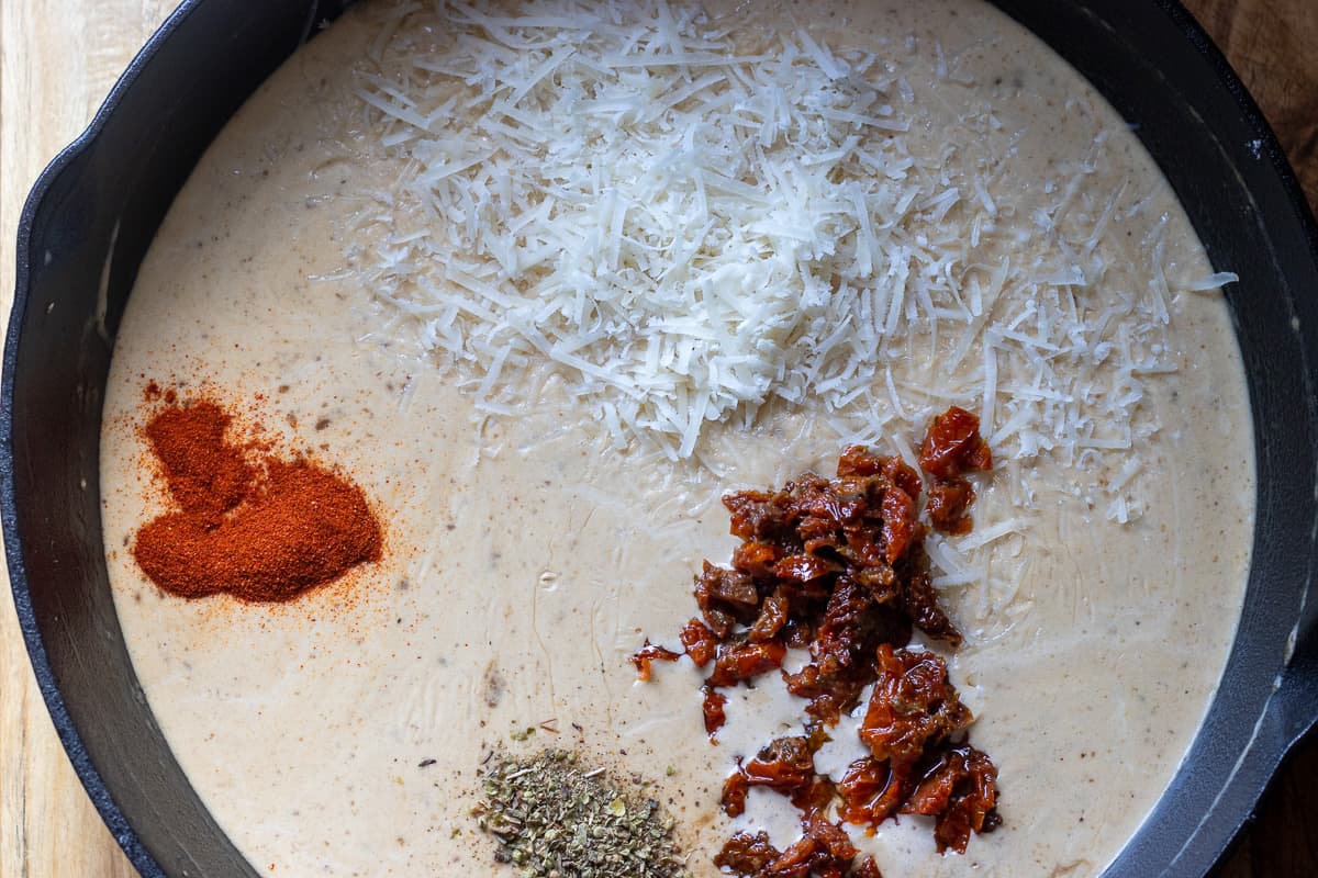 paprika, oregano, sun dried tomatoes and parmesan cheese are added to the sauce
